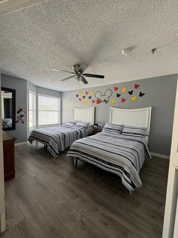 a bedroom with two beds and a ceiling fan at FMH Property Management in Orlando