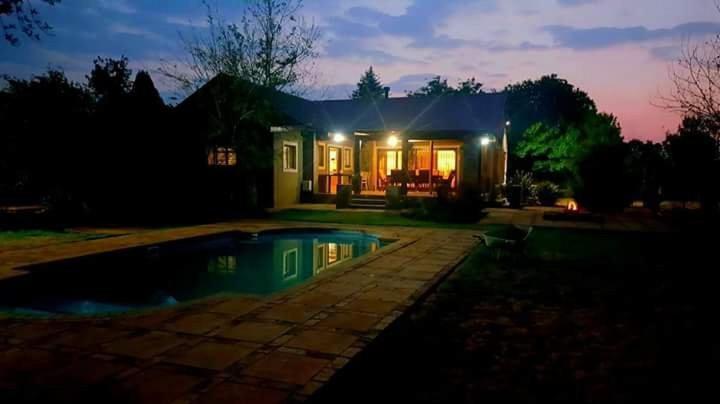 a house with a pool in the yard at night at Arum Lily Eloff in Delmas