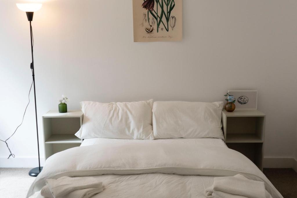 a white bed with white sheets and pillows at Bridge & Shard Hideaway in London