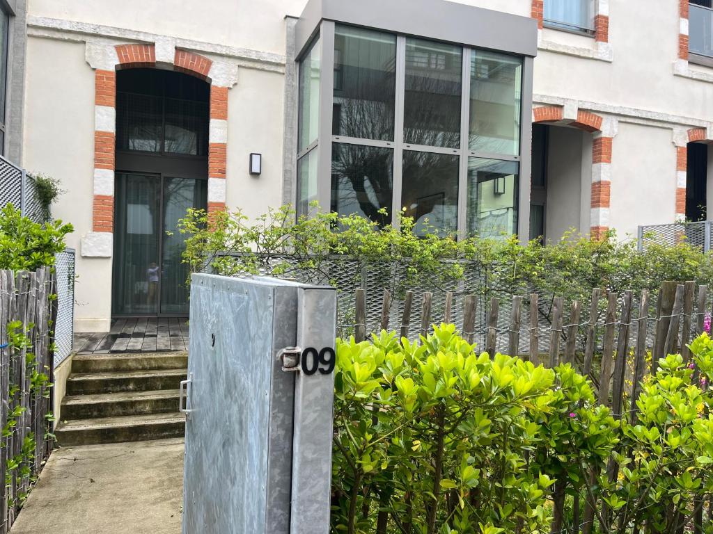une maison avec une porte en métal devant une clôture dans l'établissement Duplex à 10 min de La Rochelle, à La Rochelle