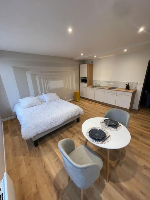 une chambre avec un lit, une table et des chaises dans l'établissement Appartement hyper cosy, à Boulogne-sur-Mer