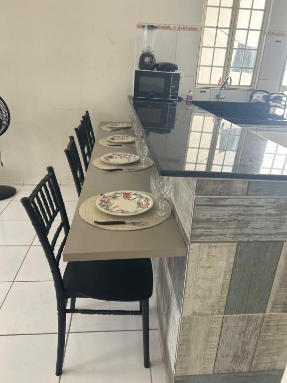 une cuisine avec une table, des chaises et des assiettes. dans l'établissement Até 08 pessoas, próximo ao shopping com garagem, à Petrolina
