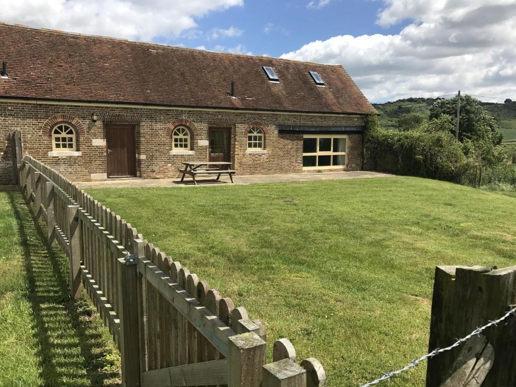 a brick building with a fence in front of it at The Homestead in Leighton Buzzard