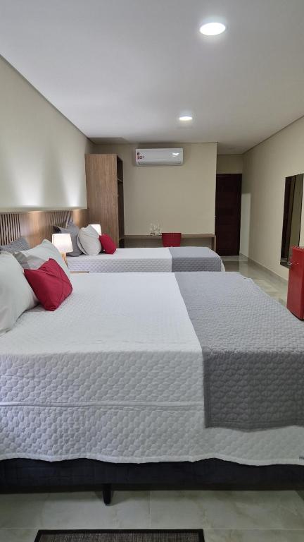 two large beds in a hotel room with two beds at Pousada Recanto Família Suíte com Hidro in Paraty