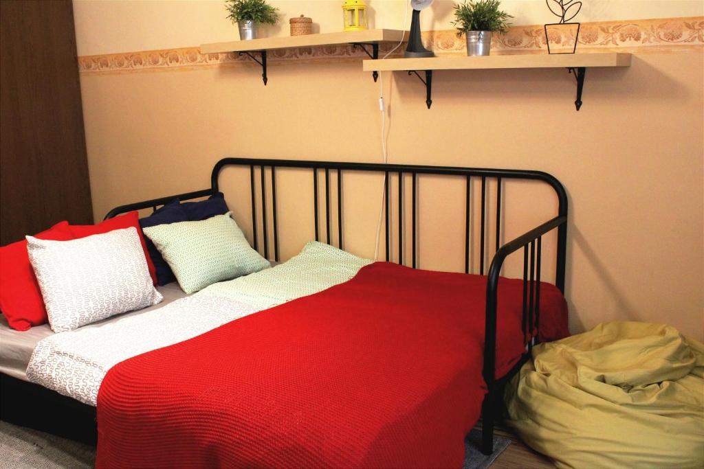 ブダペストにあるLEM Family Apartmentのカラフルな枕が付いたベッド1台が備わる客室です。