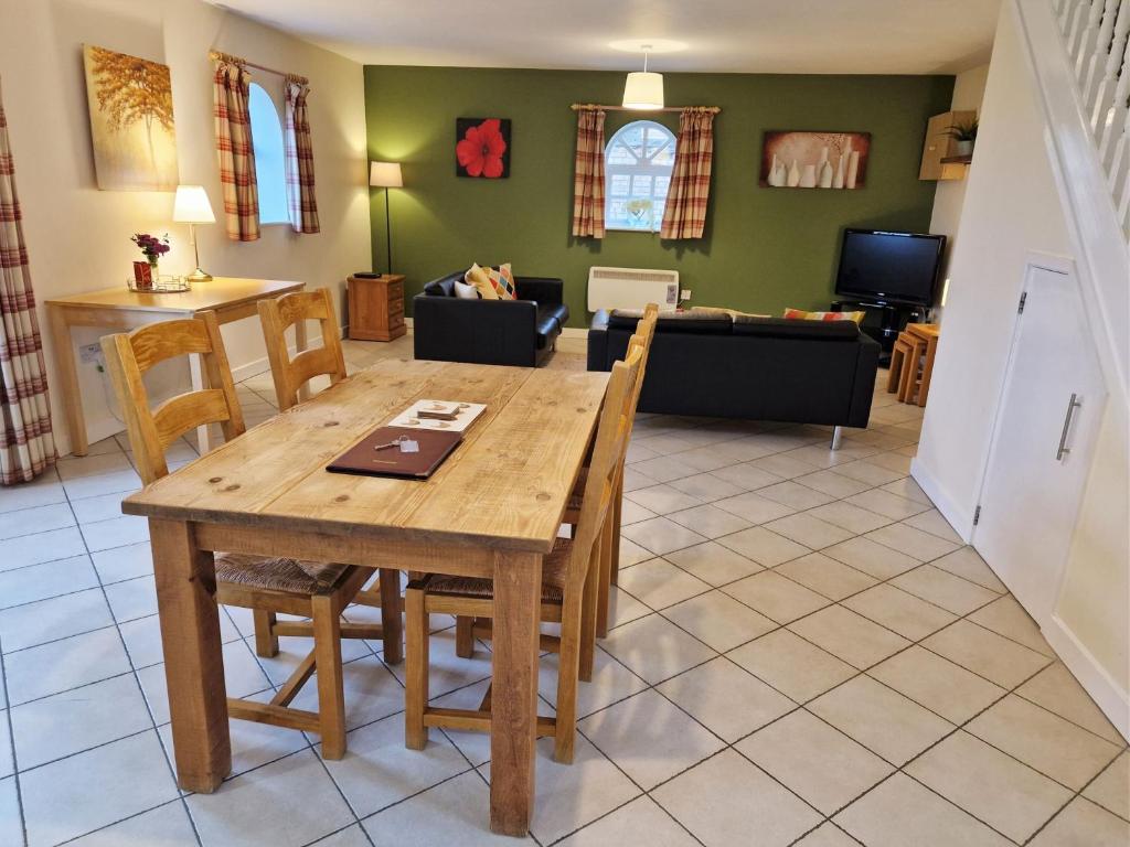 a dining room and living room with a table and chairs at Lime Kiln in Leighton Buzzard