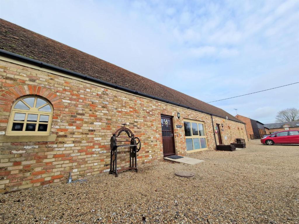 um edifício de tijolos com um portão em frente em Town End em Leighton Buzzard