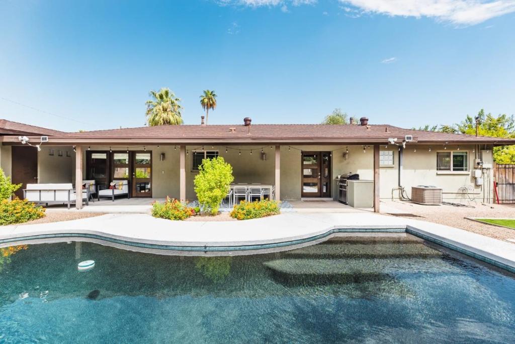 a house with a swimming pool in front of a house at Heated Pool Outdoor Kitchen Patio Modern Design in Scottsdale