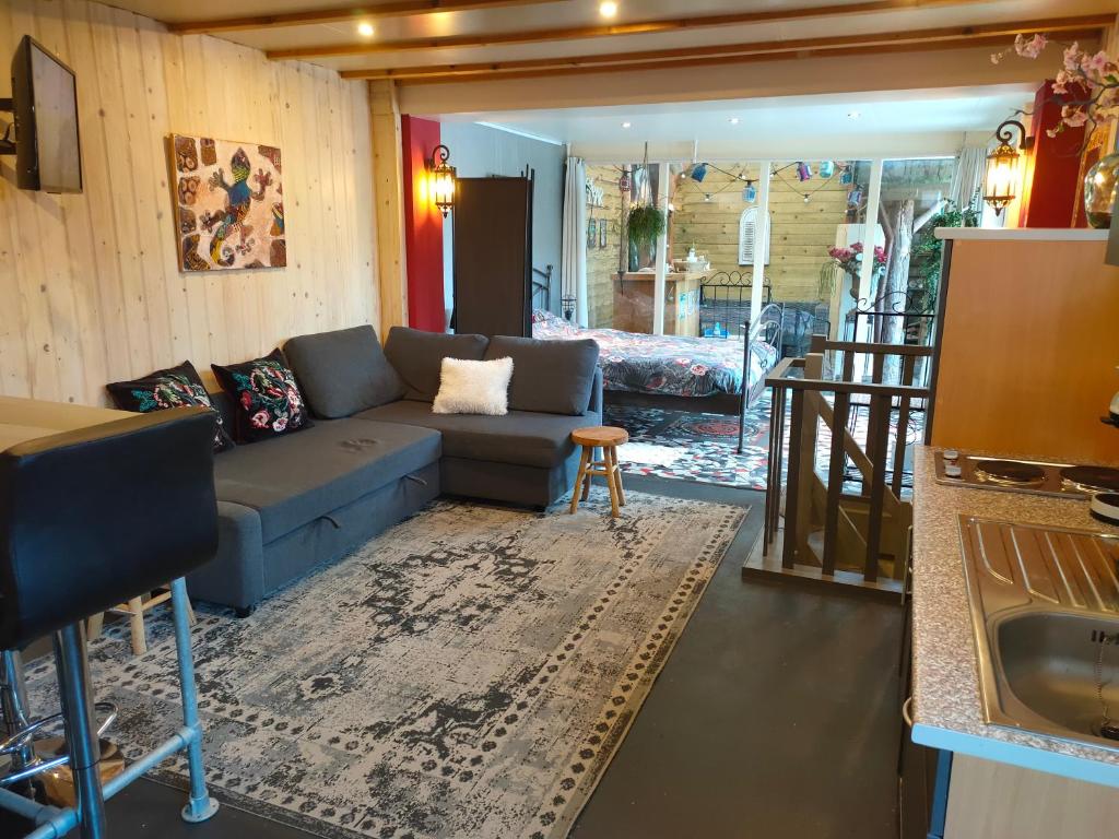 een woonkamer met een bank en een tafel bij Gastenverblijf 'De Hupsakeet' in Barneveld