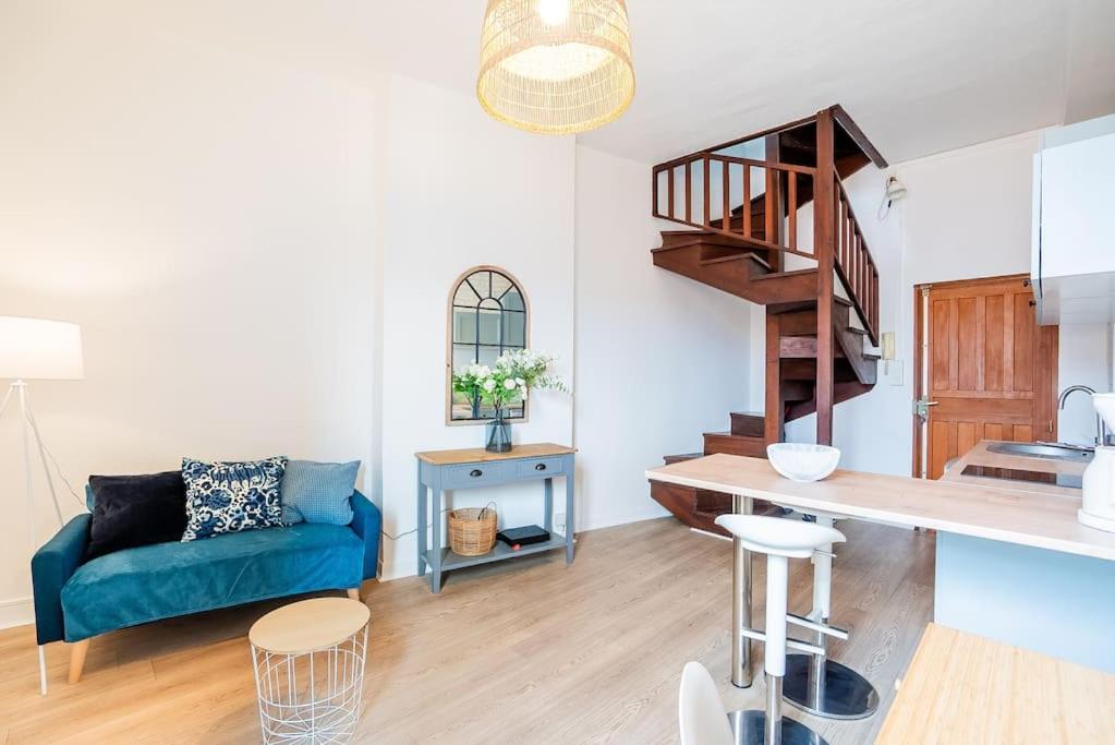 - un salon avec un canapé bleu et un escalier dans l'établissement Le Tiffany, Beau T2 en Duplex, Beaux Arts, à Montpellier