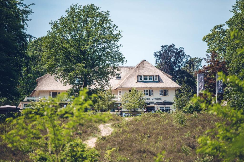 una casa en la cima de una colina con árboles en Landgoed De Uitkijk Hellendoorn en Hellendoorn