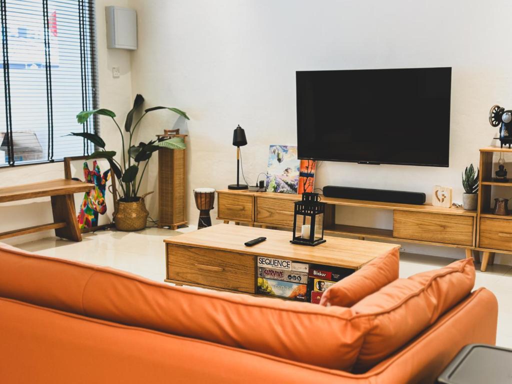 un soggiorno con divano e TV a schermo piatto di Urban ArtHouse Homestay - Permai, Sibu, Sarawak a Sibu