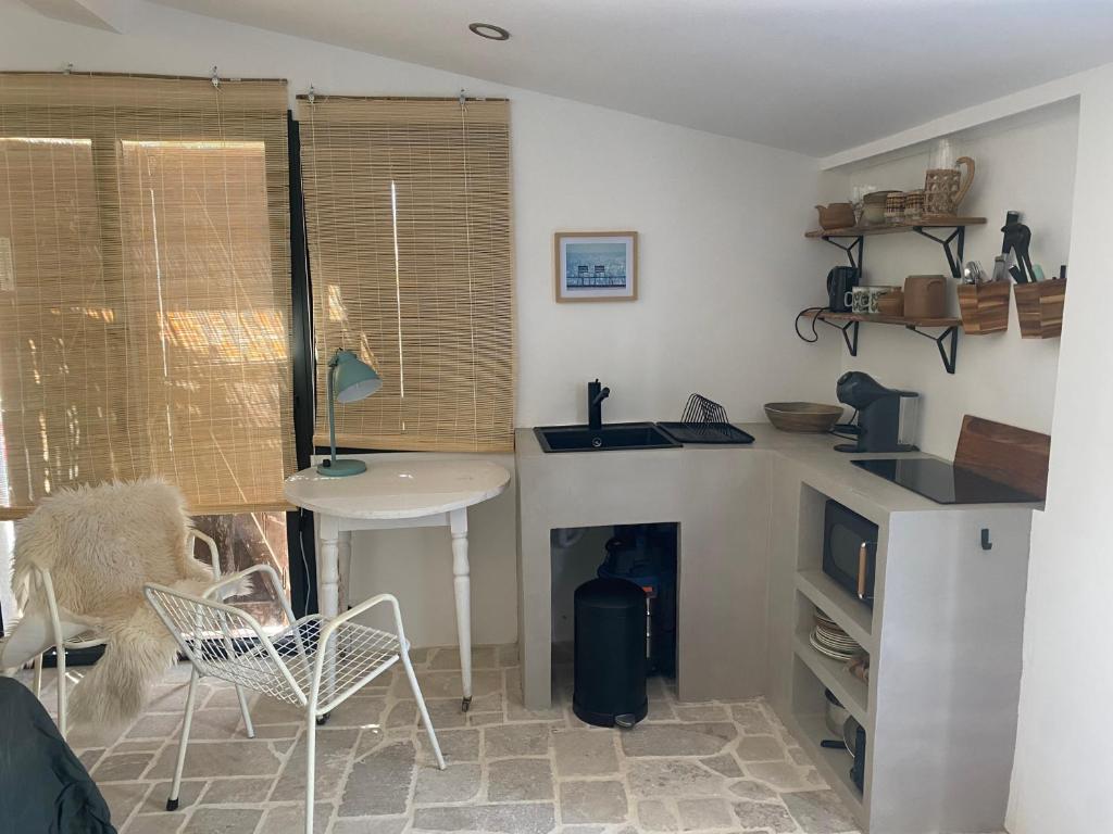 ein Wohnzimmer mit einem Tisch und eine Küche mit einem Kamin in der Unterkunft Cabanon d’Amata in Saint-Raphaël