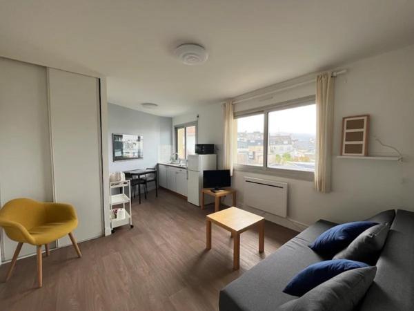 een woonkamer met een bank en een tafel bij Le Sextant Conciergerie Yourhosthelper in Larmor-Plage