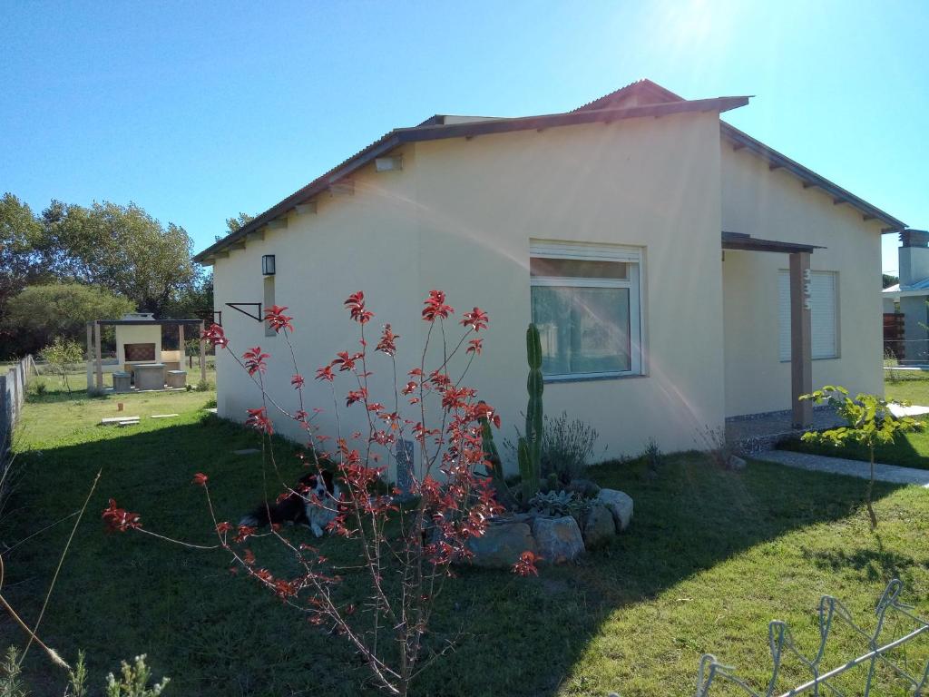 a small white house with a plant in the yard at Lafiaca in Sierra de la Ventana