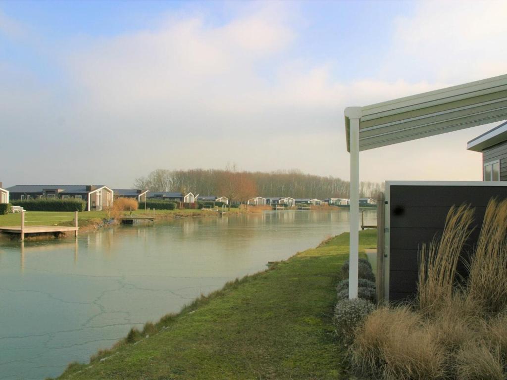 ein Wasserkörper mit einem Haus und einem Fluss in der Unterkunft Beautiful holiday home with decorative fireplace in Wemeldinge