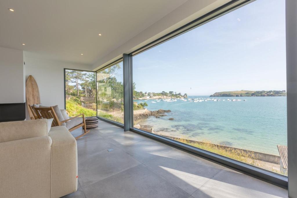 sala de estar con ventanas grandes con vistas al océano en Villa Galeo - Maison d'exception à Rotheneuf en Saint-Malo