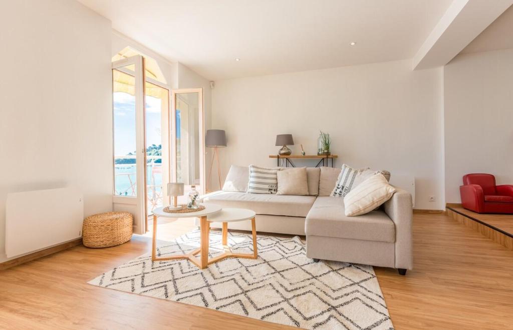 a living room with a couch and a table at Les Pieds Dans L'Eau - Bel appartement - Vue mer in Cancale