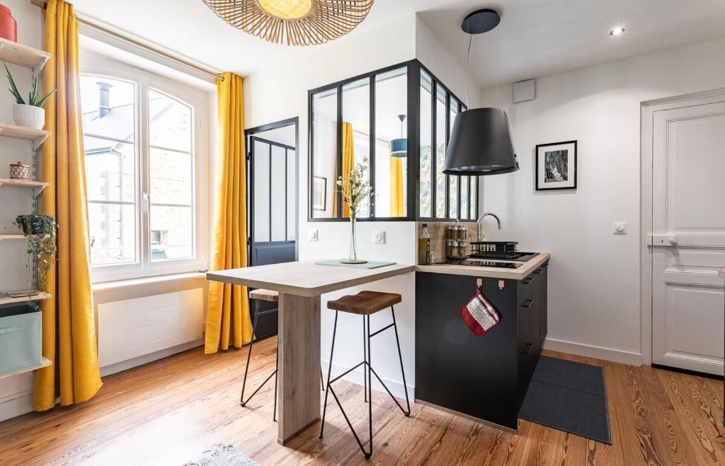 a kitchen with a counter and a table in a room at Lucelyne - Beau T2 rénové - Centre - Plage 400m in Dinard