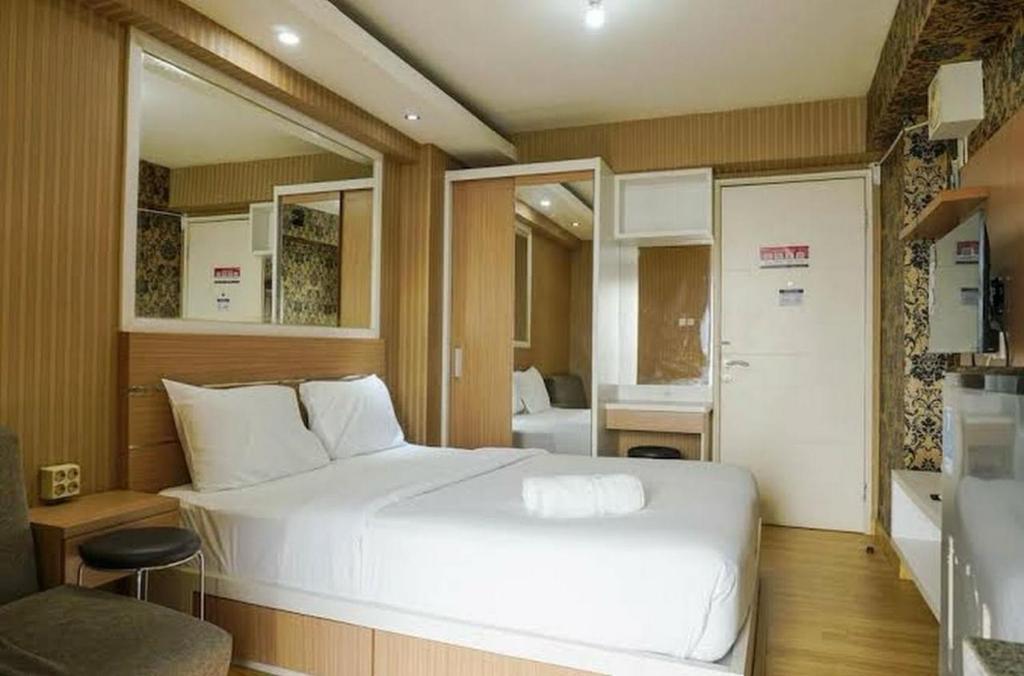 1 Schlafzimmer mit einem großen weißen Bett und einer Küche in der Unterkunft bassura city 1 in Jakarta