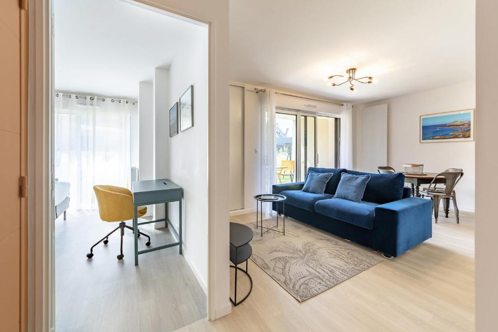 - un salon avec un canapé bleu et une table dans l'établissement L'Equinoxe, T2 de plain-pied dans résidence neuve., à Saint-Malo