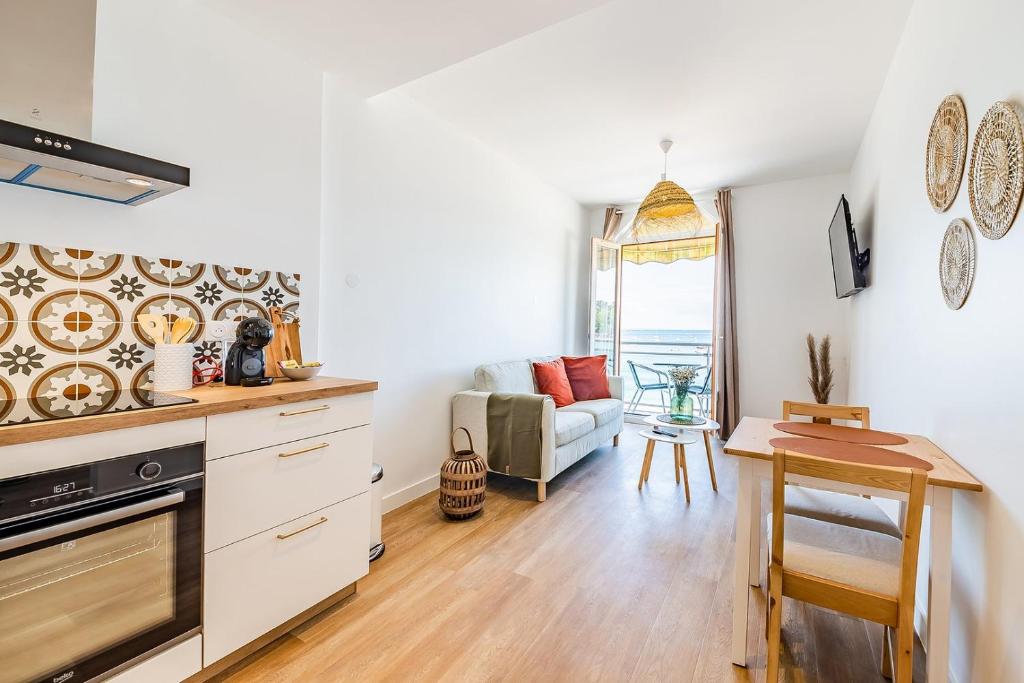 a kitchen and living room with a couch and a table at Les Pieds Dans L'Eau - Appartment 1 - Vue mer in Cancale