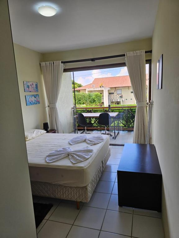um quarto de hotel com uma cama e uma varanda em FLAT MONTE CASTELO GRAVATA em Algodões