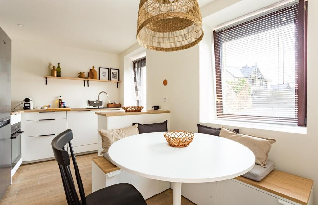 uma cozinha e sala de jantar com uma mesa branca em Saint Alexandre - Jolie maison atypique -Terrasse em Dinard