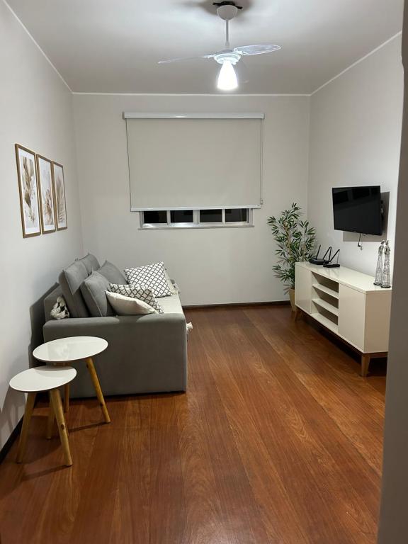 a living room with a couch and a table at Apartamento Centro ao lado do Country Club in Nova Friburgo