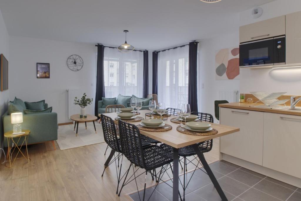 cocina y sala de estar con mesa y sillas en Le Normand- appartement neuf, 3 chambres, terrasse, en Rennes