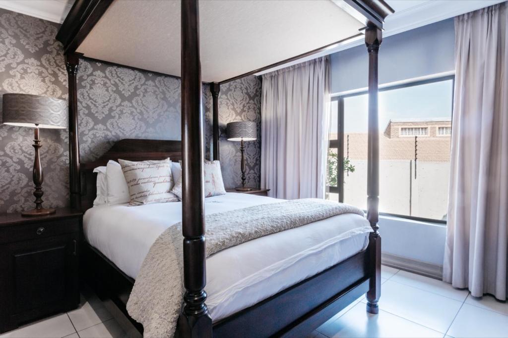 1 dormitorio con cama con dosel y ventana grande en Tramonto House en Newcastle