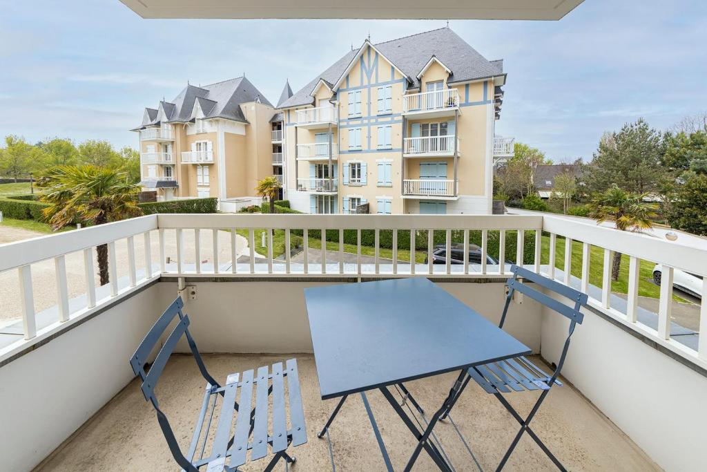 una sedia blu su un balcone con un edificio di Ty Azur, charmant 2 pièces avec balcon a Dinard