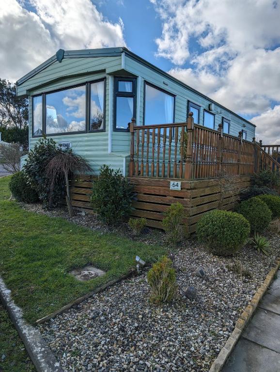 a blue tiny house with a large deck at 64 Wide Horizon in Aberaeron