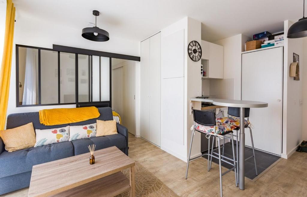 een woonkamer met een blauwe bank en een tafel bij L'Ivoire - Joli appartement - 1 chambre avec in Rennes