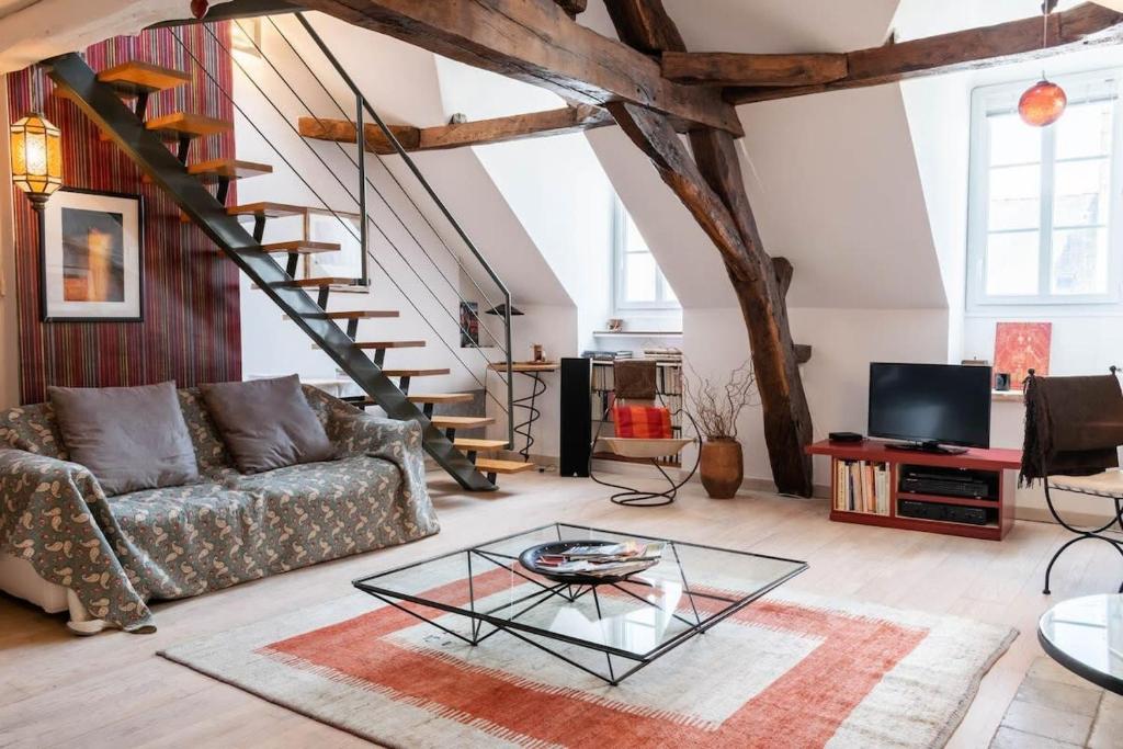 uma sala de estar com um sofá e uma mesa de vidro em L'Opéra , appartement cosy, centre historique em Rennes