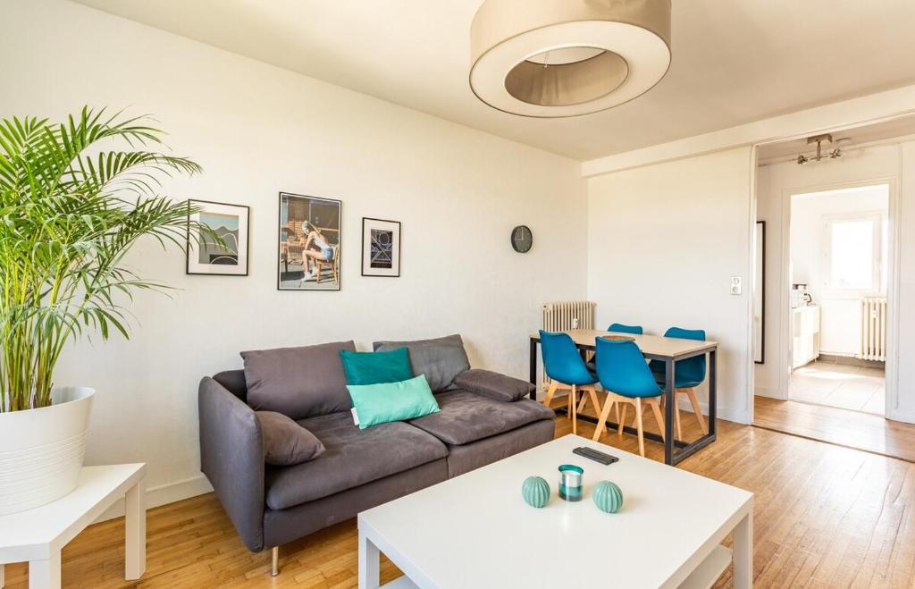 een woonkamer met een bank en een tafel bij L'Horizon appartement 3 chambres moderne - 6 pers in Rennes