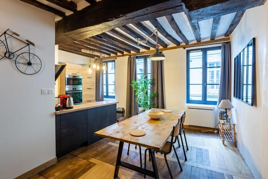cocina y comedor con mesa de madera y sillas en Le Jacobin appartement de standing - Hyper centre en Rennes