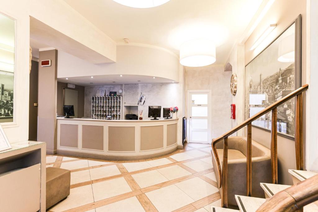 a lobby with a staircase and a counter at Albergo Firenze in Florence