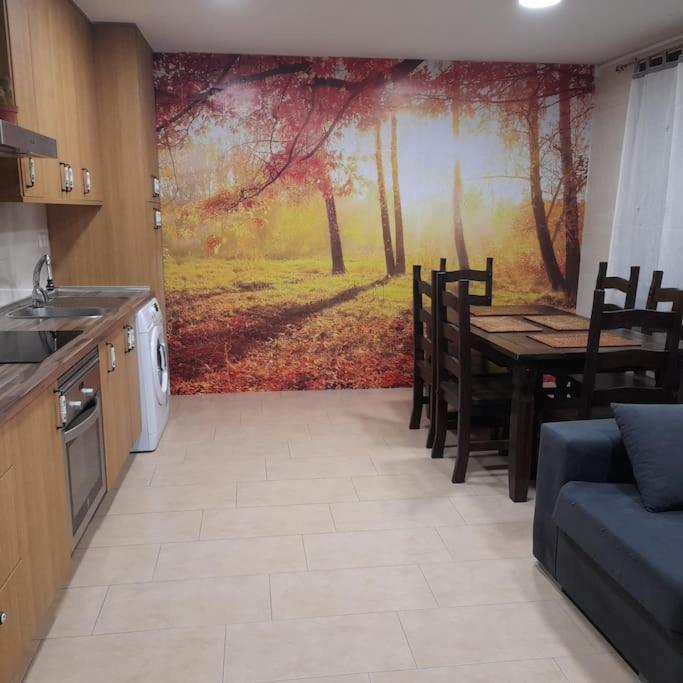 uma cozinha com uma mesa e um quadro na parede em Plaza de Chinchón. Apartamento. em Chinchón