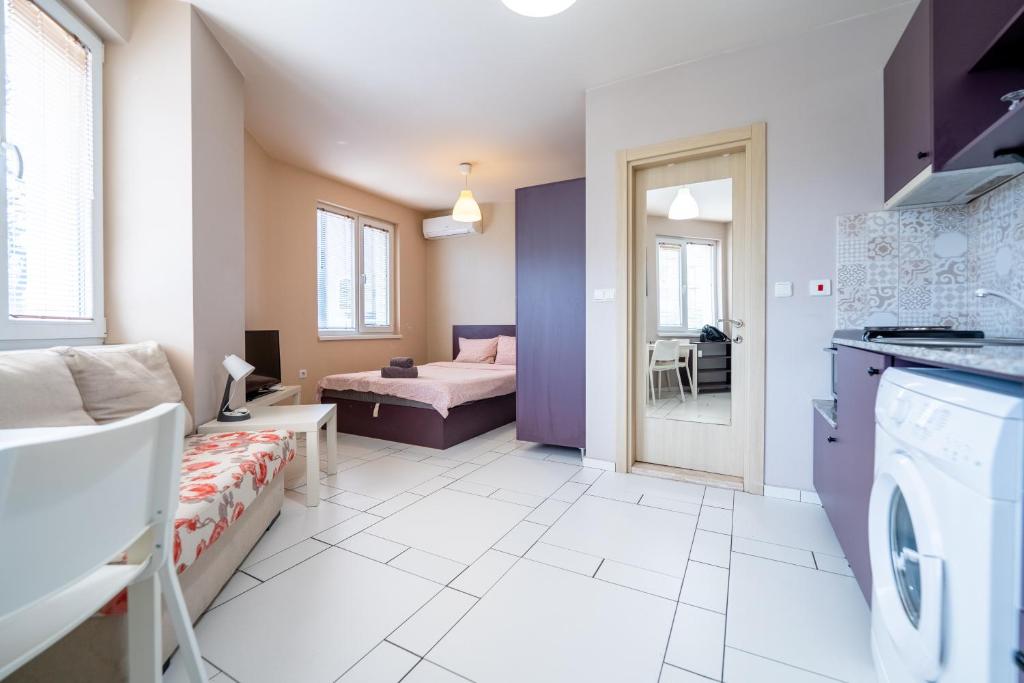 a living room with a couch and a bed in a room at Funky apartment in Studentski Grad in Sofia