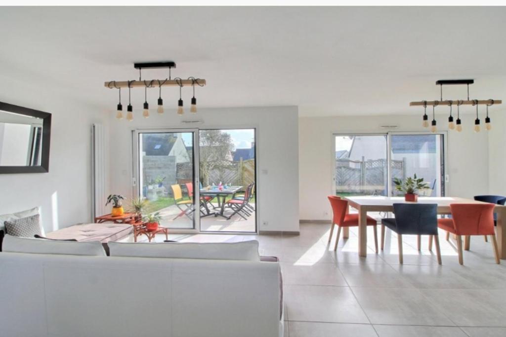 un salon blanc avec une table et des chaises dans l'établissement Les Marquises - bord de mer, à Roscoff