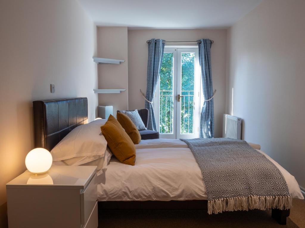 a bedroom with a bed with a window at By the River in Glasbury