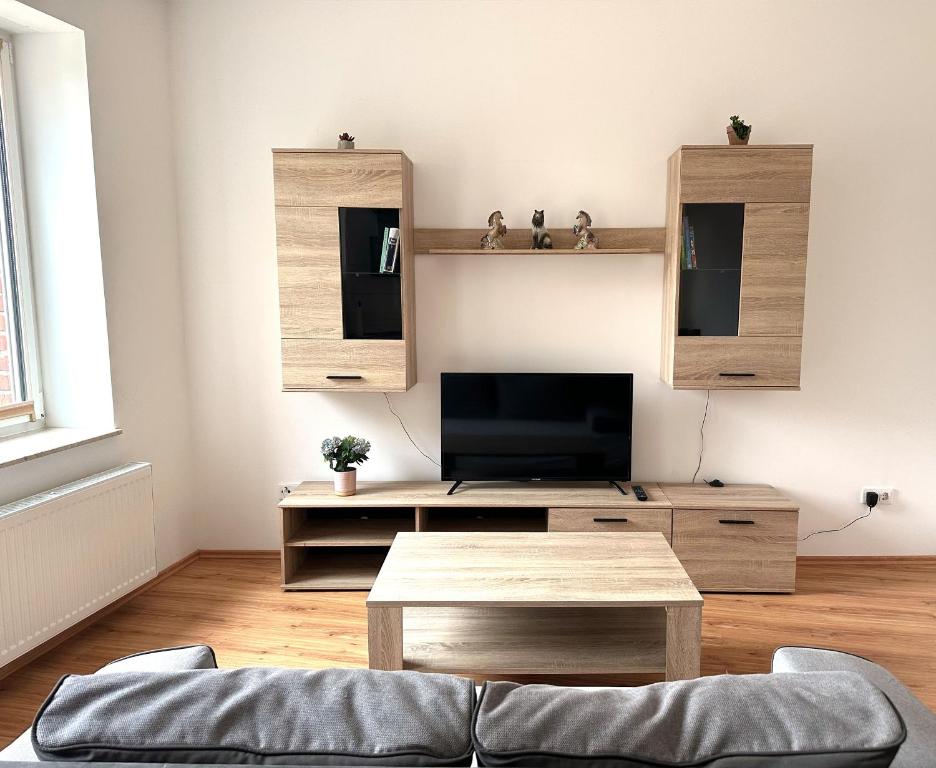 een woonkamer met een tv en een tafel bij Vila Bösdorf Apartments in Rätzlingen
