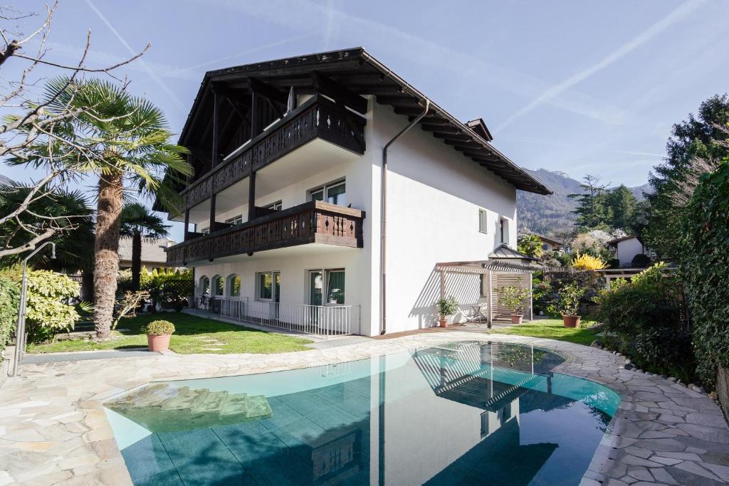 a house with a swimming pool in front of it at Hotel Garni Sirmian in Merano