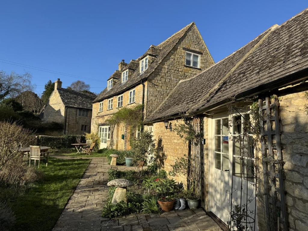 un gruppo di vecchi edifici in mattoni in un cortile di Guiting Guest House a Guiting Power