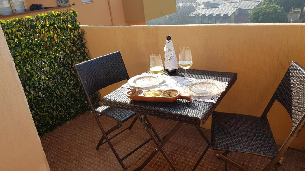 una mesa con dos copas de vino y una bandeja de comida en Casa Allegra en Chioggia