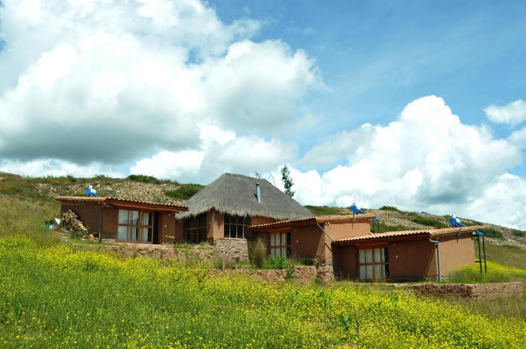 ein Gebäude mit einem Grasdach auf einem Hügel in der Unterkunft Pampachayoq - Mountain retreat in Urubamba