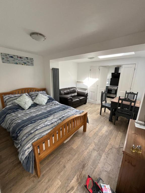 um quarto com uma cama e uma sala de estar com um piano em Seagull studio em Felixstowe