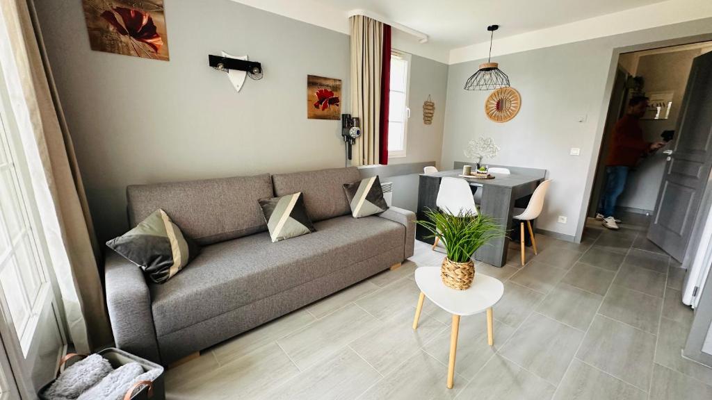 ein Wohnzimmer mit einem Sofa und einem Tisch in der Unterkunft appartement en residence au golf in Biscarrosse