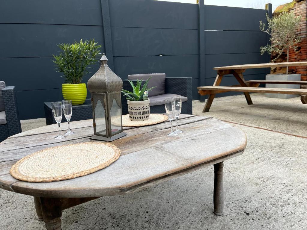 una mesa de madera con copas de vino encima en Maison 6 chambres en Beauvais